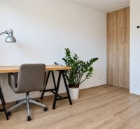 A workspace with a desk, plants, and a wooden decor floor in a 3-room apartment.