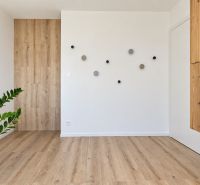 Interior of a 3-room apartment with a wooden decor floor and wall decoration.
