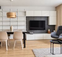 Living room in a three-room apartment with a wooden decor floor and white furniture.