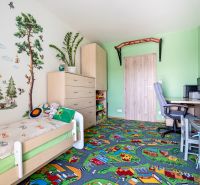 Children's room in a 3-room apartment with playful wallpaper and a colorful carpet.