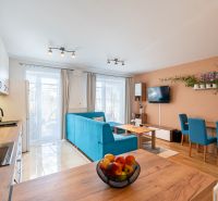 Open kitchen and living area in a 3-room apartment with a wooden decor floor.