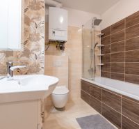 A bathroom with a bathtub and tiles in a 3-room apartment, floor with wooden decor.