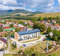 A view of 3-room apartments in Mikušovce with surrounding greenery and hills.