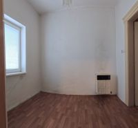 A room in a family house with a wooden decor floor and a heating unit.