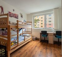 Children's room with a bunk bed and a desk in a 3-room apartment with a wooden decor floor.