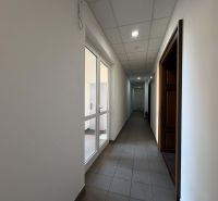 A corridor with tiles and white walls leads to other offices.