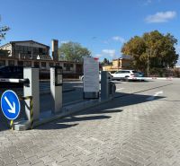 Fenced entrance to the office parking lot in Komárno with an automatic barrier.