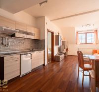 A kitchen in a 2-room apartment with a wood-patterned floor and a dining table.