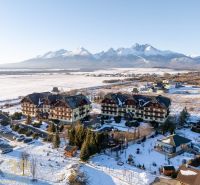 Winter scenery in Veľká Lomnica with a view of the Tatras and buildings offering 2-room apartments.