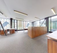 Spacious offices with desks and cabinets on a floor with wooden decor.