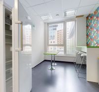 Offices with colorful wallpaper, an open refrigerator, and large windows.