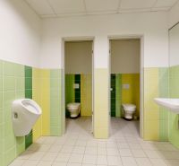 Men's restrooms with tiles in green-yellow shades, including urinals and a sink.