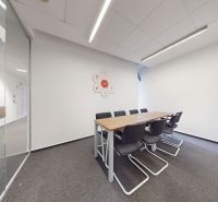 Glass doors to the meeting room, office chairs, and a desk in the office.