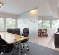 Interior of an office with large windows, a conference table, and a kitchenette.