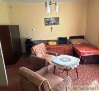 Living room of a family house with sofas, armchairs, and decorations on the walls.