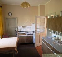 A kitchen in a family house with retro furniture and yellow curtains.
