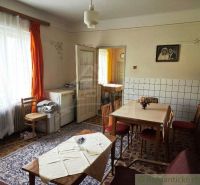 Dining room in a family house with wooden chairs, a table, and a carpet.
