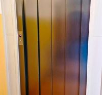 Elevator in the building, studio apartment with tiled floor, visible metal doors.