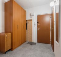 Entrance hallway in a 4-room apartment with wooden cabinets and a coat rack.