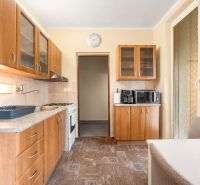 A kitchen in a 4-room apartment with cabinets and appliances; floor with wood decor.