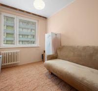 A room with a beige sofa in a 4-room apartment, a carpet, and a radiator.