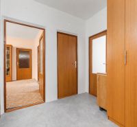 A hallway in a 4-room apartment with wooden doors and built-in wardrobes.