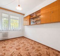 A room in a 4-room apartment with a decorated floor, a window, and a wooden shelf on the wall.