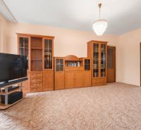 Living room with cabinets and a television in a 4-room apartment on a carpeted floor.