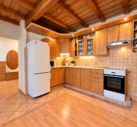 A kitchen in a 2-room apartment with a wooden decor floor and a wooden ceiling.