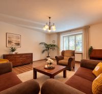 Living room in a two-room apartment with a wooden decor floor and comfortable furniture.