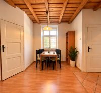 Dining area with a wooden ceiling, table, chairs, and flooring with a wooden decor in a 2-room apartment.