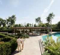 Garden and pool in the apartment complex in Phuket, lined with palm trees and greenery.