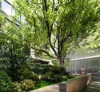 Apartment construction in Phuket with lush greenery and glass facades of buildings.