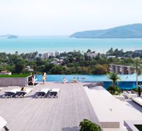 Apartment construction in Phuket with a pool and views of the sea and greenery.