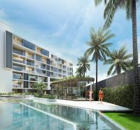 Apartment construction in Phuket with a pool and palm trees in the background.