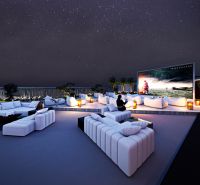 Rooftop terrace with seating and large screen, Apartment construction in Phuket.