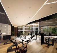 The interior of a gym with wood-patterned flooring and exercise machines. Apartment construction.