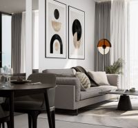 A bright interior of a 2-room apartment with a comfortable sofa and decorative paintings on the wall.