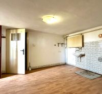 A room in a family house with a sink and a floor with a wooden decor.