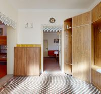 Interior of a family house with a tiled floor and furniture with a wooden decor.