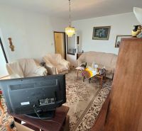 Living room with a TV and sofas in a 2-room apartment with a carpet.