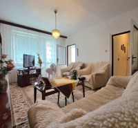 Living room in a two-room apartment with comfortable seating and a wooden decor floor.