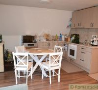 A kitchen in a cottage with wooden decor and a dining table.