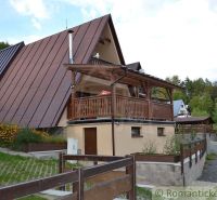 A cottage in Nižná Polianka with a sloped roof and a terrace in a natural setting.