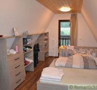 A room in a cottage with a wooden decor floor and storage cabinets.