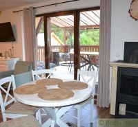 The interior of the cabin with a fireplace, dining table, television, and access to the terrace.
