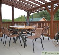 The terrace of the cottage in Nižná Polianka with a wooden table and chairs under a covered pergola.