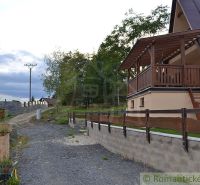 A cottage in Nižná Polianka with a wooden terrace and garden landscaping.