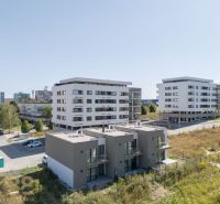 A family house in Poprad near modern apartment buildings and greenery.