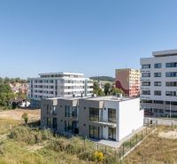 A family house in Poprad with a view of the Tatras, with cars parked in front.